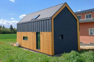Nowoczesny dom modułowy Perfect Cube w Swisttal w Niemczech z elewacją drewnianą i grafitową blachą na rąbek w minimalistycznym stylu nowoczesnej stodoły. Nowoczesny dom modułowy Perfect Cube w Swisttal w Niemczech z elewacją drewnianą i grafitową blachą na rąbek w minimalistycznym stylu nowoczesnej stodoły.